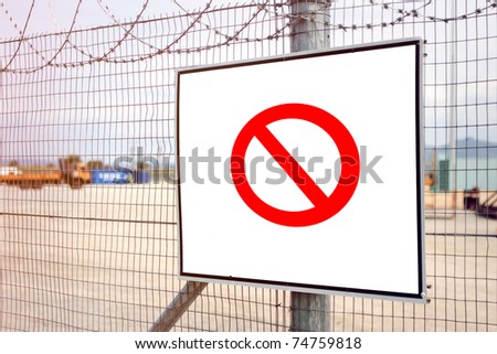 Red no entry sign on industrial fence