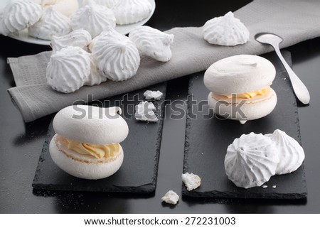 meringue cakes lie on a dark table