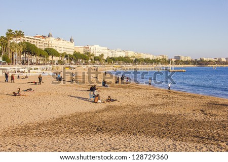 CANNES, FRANCE - FEBRUARY 16: Tourists enjoy the good weather at the beach on February 16, 2013 in Cannes, France. The beach and the waterfront avenue, La Croisette, are full almost all the year round