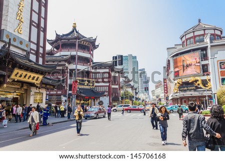 SHANGHAI, CHINA - APRIL 25: People walking in the Chenghuangmiao area on April 25, 2011 in Shanghai, China. The place is a popular shopping center and it\'s famous for the typical Chinese buildings.