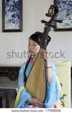 SHANGHAI, CHINA - APRIL 26: A woman holding a pipa at a concert in the garden Yu on April 26 2011 in Shanghai, China. Pipa is a plucked Chinese instrument with four strings.