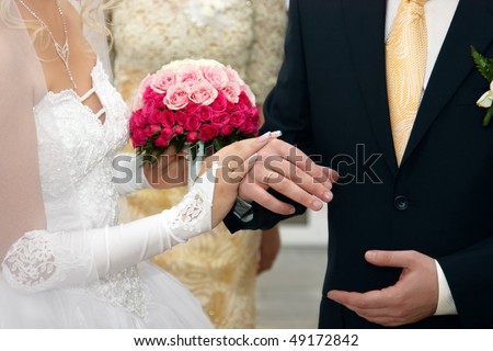 stock photo Bride And Groom Hands with Wedding Rings and Flowers Bouquet