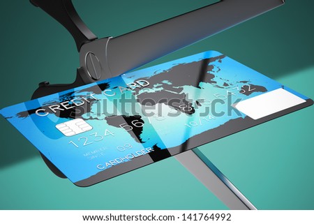 Closeup on scissors cutting credit card on a green background. Might represent recession, bankruptcy or any financial related matters.