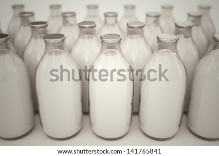 Front shot of old-fashioned glass bottles filled with milk on a white backround. Perfect for any health or natural nutricion realted purposes.