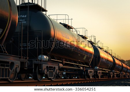 Transportation tank cars with oil during sunset.