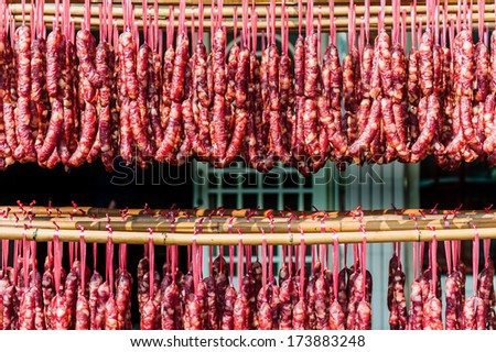 Home made meat salami sausage at street market hanging in line under sunlight to make good tasty.