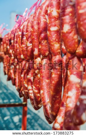 Home made meat salami sausage at street market hanging in line under sunlight to make good tasty.