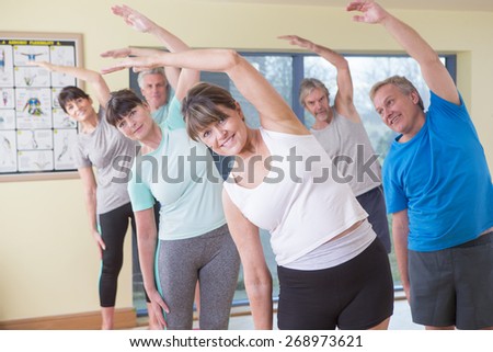 Group of seniors stretching together at the gym