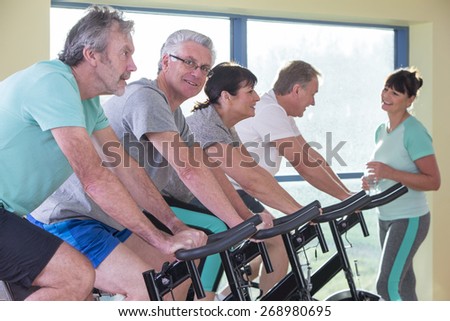 A group of seniors using the spinning bikes at the gym