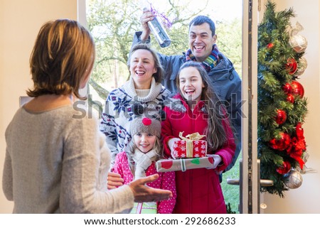 Family delivering Presents at Christmas time. They all look happy and ready to celebrate.