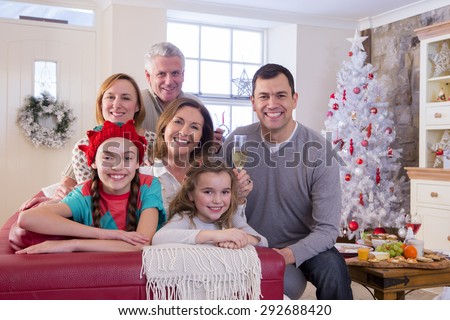 Three Generation Family at Christmas Time. They are all Smiling and looking at the Camera.