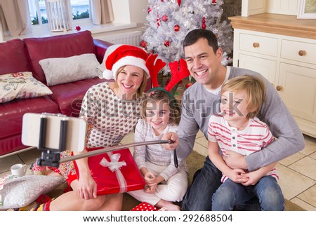 Two Generation Family taking a Self Portrait at Christmas. They are Smiling at the Camera.