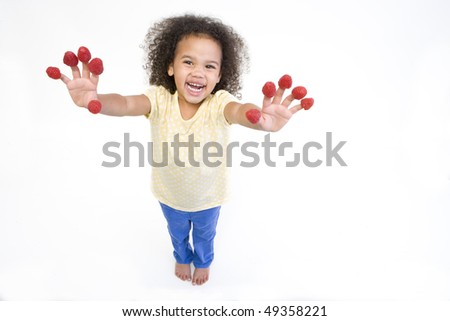 Getty Images - Close up of woman biting raspberries on fingertips
