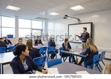 Male teacher is teaching a group of teenagers in a high school lesson.