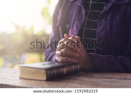 Christian woman holding hands and praying with bible,Pleading to God, Christian and prayer concept.