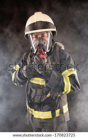 Firefighter wearing protective suit, helmet and mask