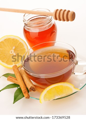 Tea in glass cup with honey, lemon and cinnamon