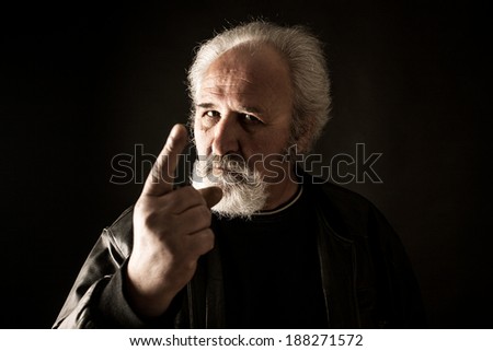 Grumpy man against black background