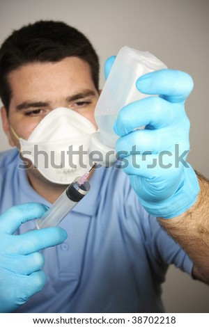 Young adult man with mask, gloves, syringe and bottle