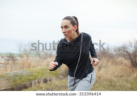 Running woman. Sportive girl is doing workout and running in a park.