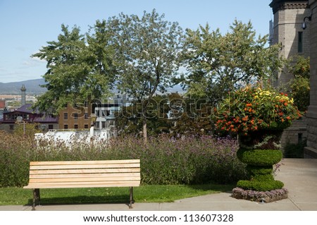 Park bench in Quebec City with ornamental plant stand