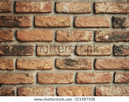 Red aged brick wall wallpaper closeup.