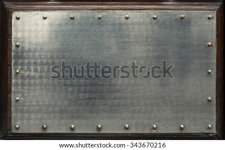 Polished metal plate on wood background.