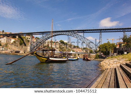 Tradicional vintage port transporting boats near famous bridge Ponte dom Luis, Portugal