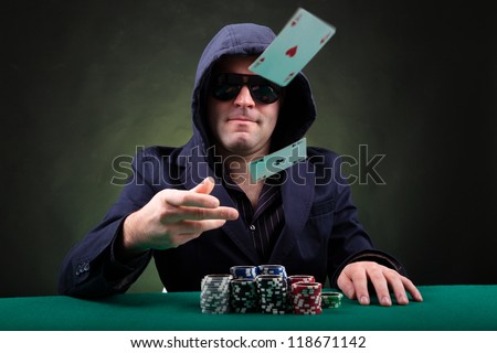 Poker player throwing two ace cards on black background