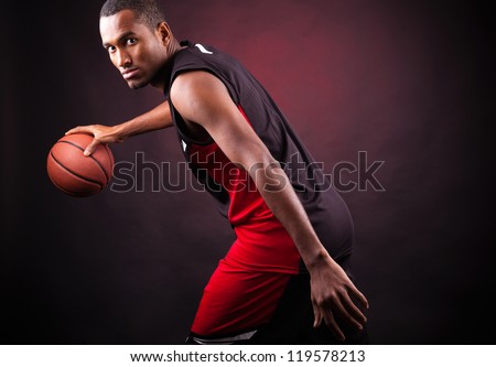 Portrait of a young male basketball player against black background