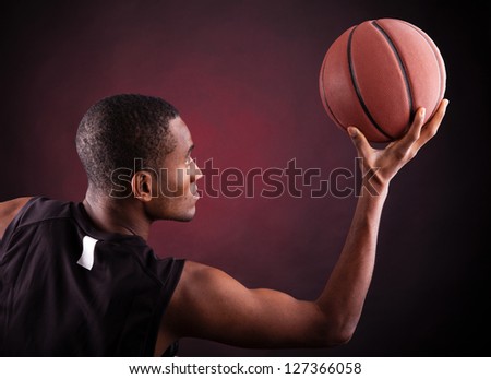 Male basketball player against black background