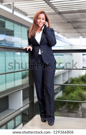 Young business woman talking on cell phone at the office