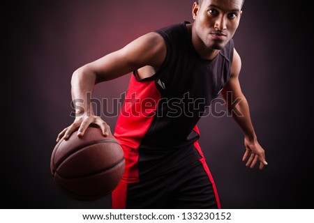Portrait of a young male basketball player against black background
