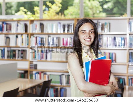Portrait of pretty girl looking at camera in college library