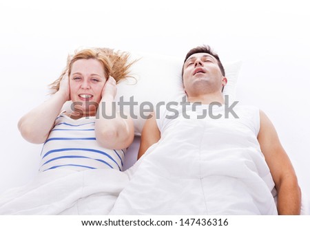 Snoring man, woman can not sleep, covering ears with pillow for snore noise