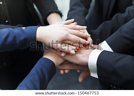Business partners making pile of hands at meeting
