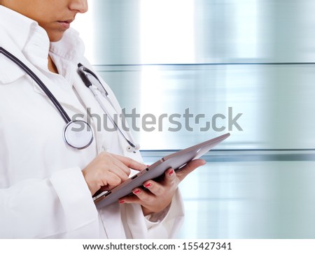 Confident female doctor using tablet computer in corridor of the hospital