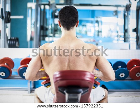 Back view of a stong man ready to lifting weights in the gym