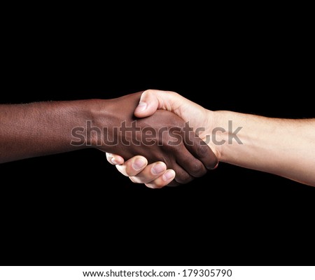 Handshake between african and a caucasian man over black background