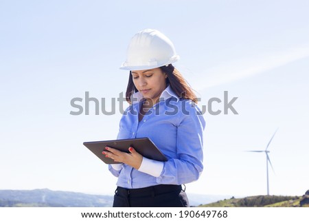 Female engineer working with a tablet at wind farm