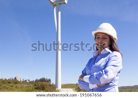 Beautiful engineer standing at wind farm