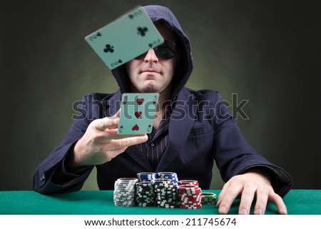 Poker player throwing two cards on black background