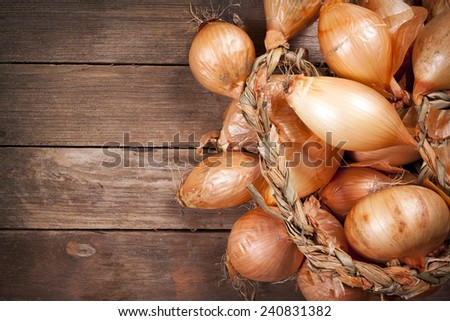 Heap of onions on wooden background