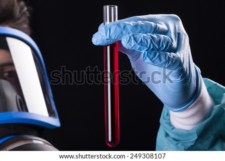 Scientist holding a sample of blood on black background