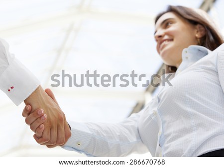 Beautiful businesswoman giving a handshake and smiling