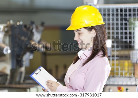 Mechanical engineer taking notes at metallurgy factory