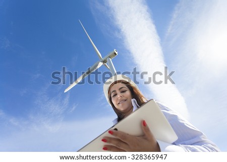 Environmental engineer with a tablet computer at wind farm