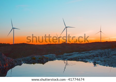 windmills at sunset in the top of a montain, alternative energy source