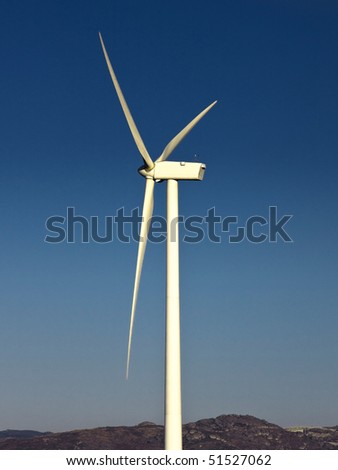 windmil in the top of a montain with blue sky, alternative energy source