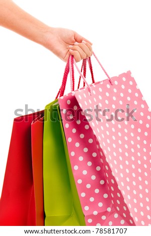 close-up of female hand holding colorful shopping bags